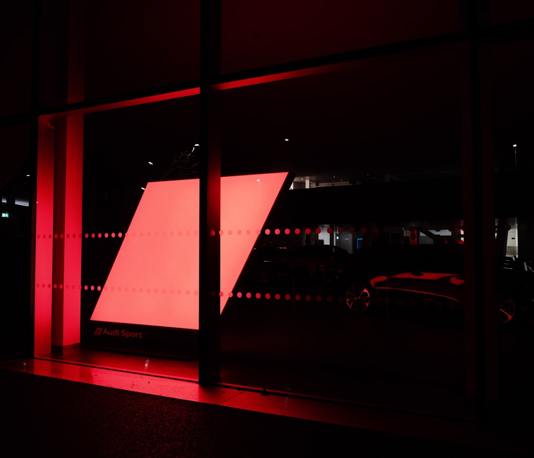 Red geometric shape illuminated behind glass at night.