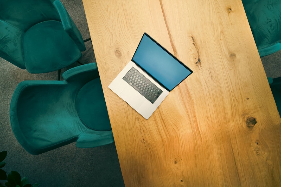 A laptop computer sitting on top of a wooden table