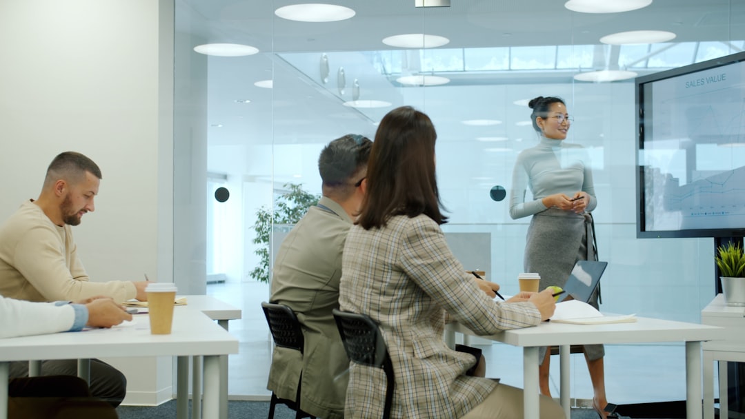 Woman presenting to colleagues in a modern office meeting.