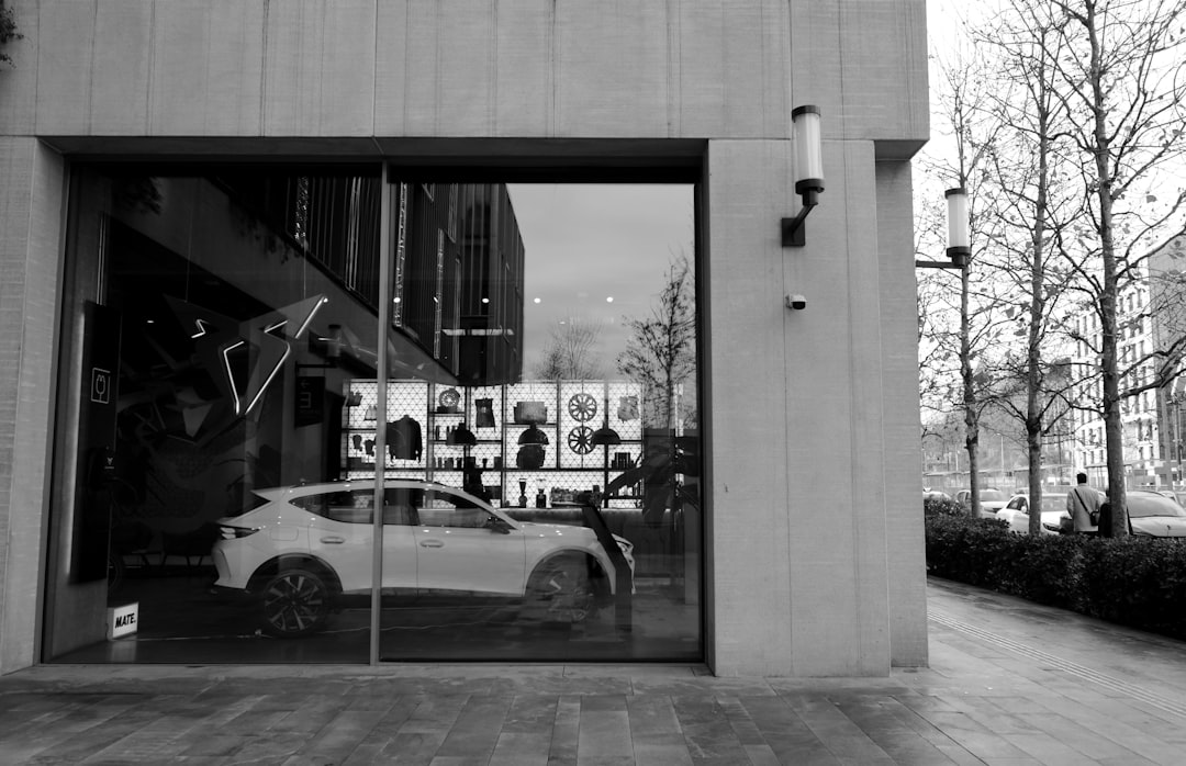 White car displayed in a modern storefront window.