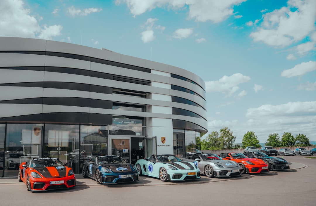 Several porsches parked in front of a dealership.