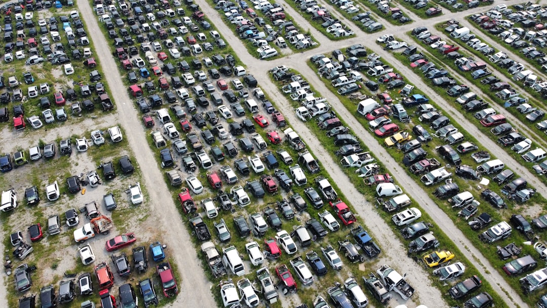 Aerial view of a large car junkyard with many vehicles.