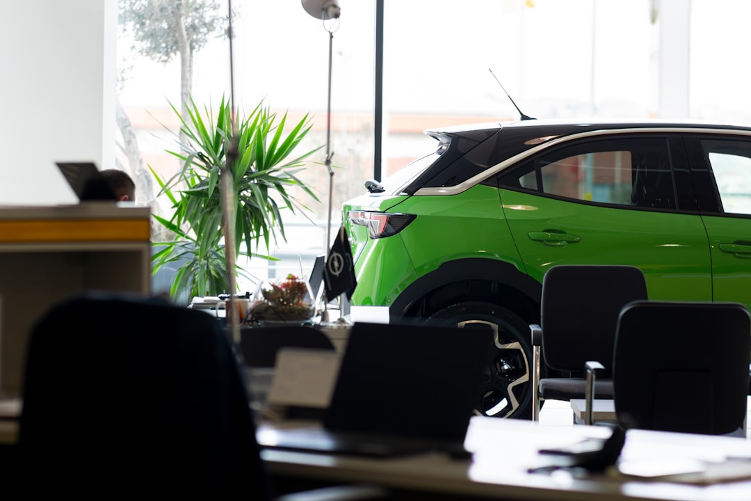A green car is parked in an office