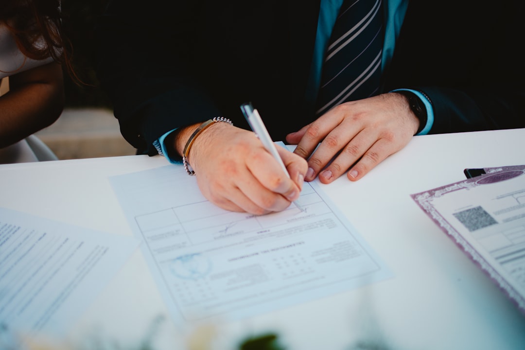 Person signing a document with a pen.