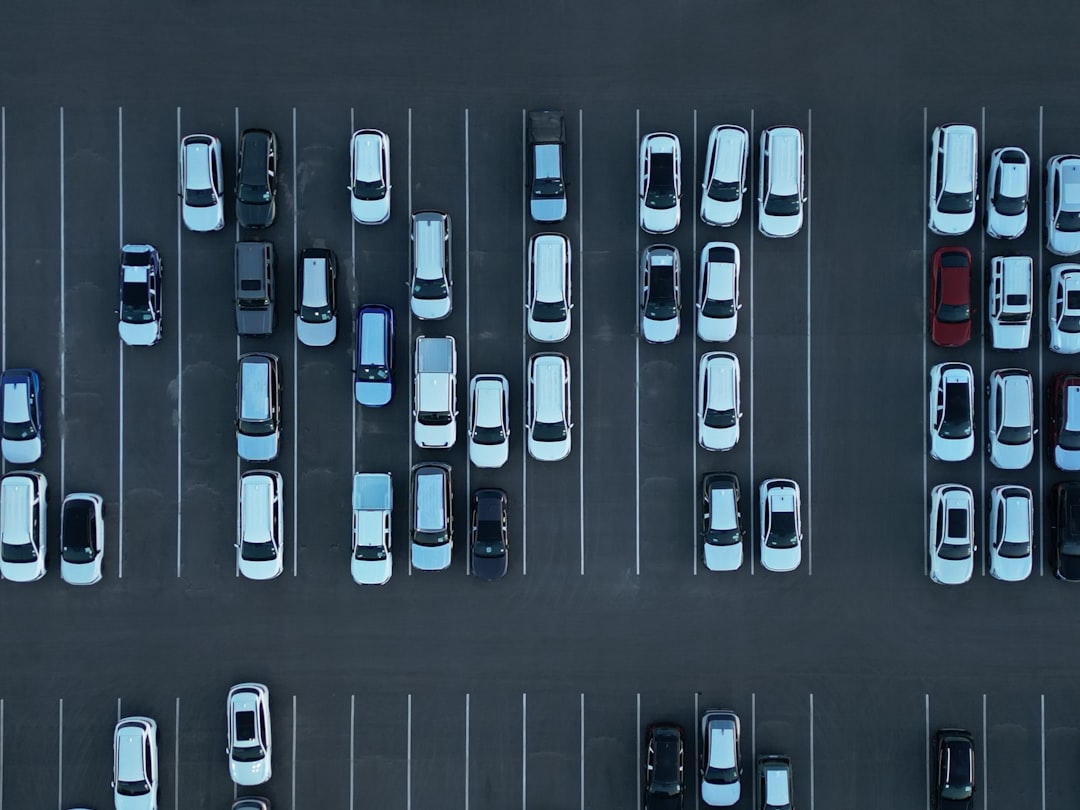 Aerial view of a nearly empty parking lot with cars.